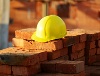Image of a yellow construction hat and red building bricks